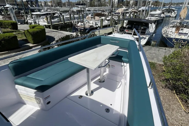 Slide: The Image of 2023 Axopar 28 Cabin boat with seating and table at marina. - 20