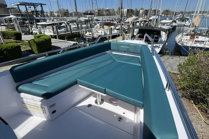 Slide: The Image of 2023 Axopar 28 Cabin boat with teal seating, docked at a marina. - 21