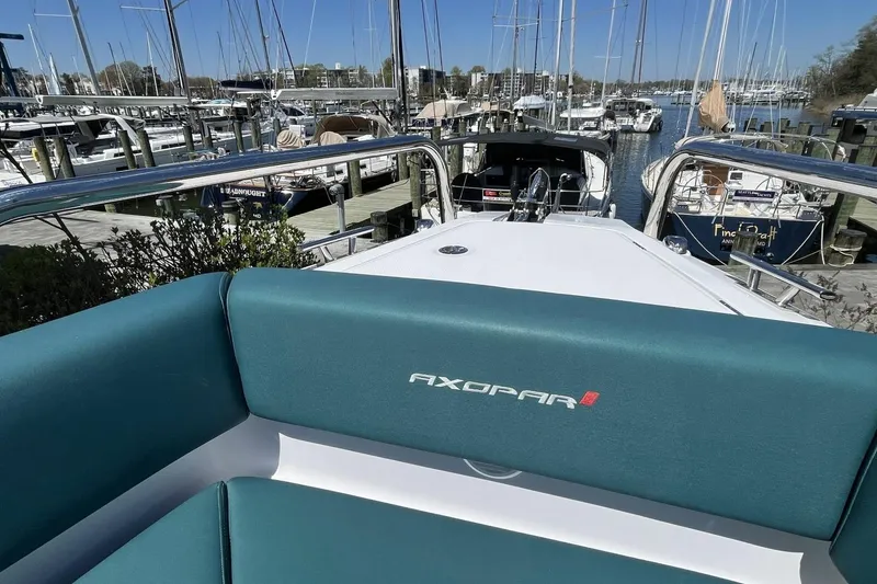 Slide: The Image of 2023 Axopar 28 Cabin boat docked at a marina with surrounding yachts. - 24