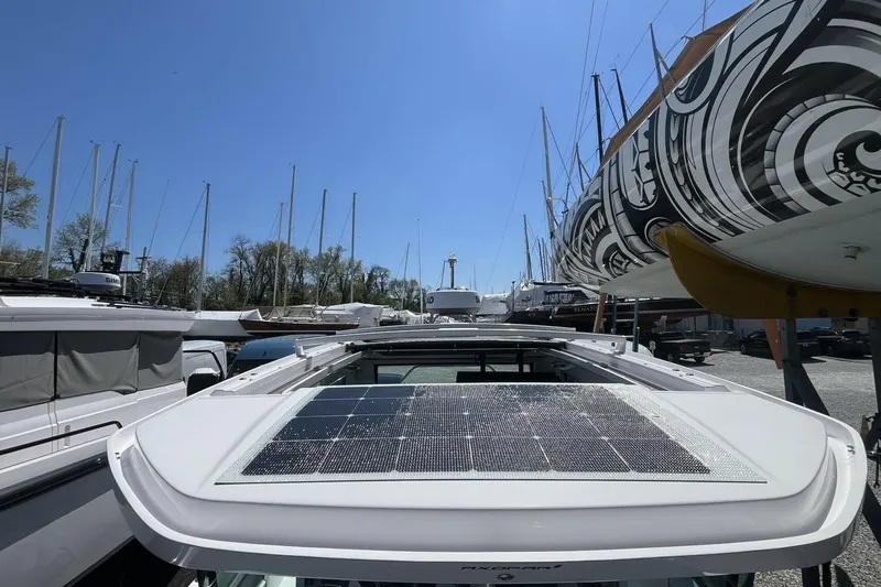 Slide: The Image of 2023 Axopar 28 Cabin with solar panel, docked among sailboats. - 28
