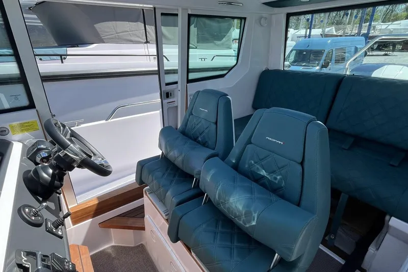 Slide: The Image of Interior of 2023 Axopar 28 Cabin with blue seating and steering wheel. - 31