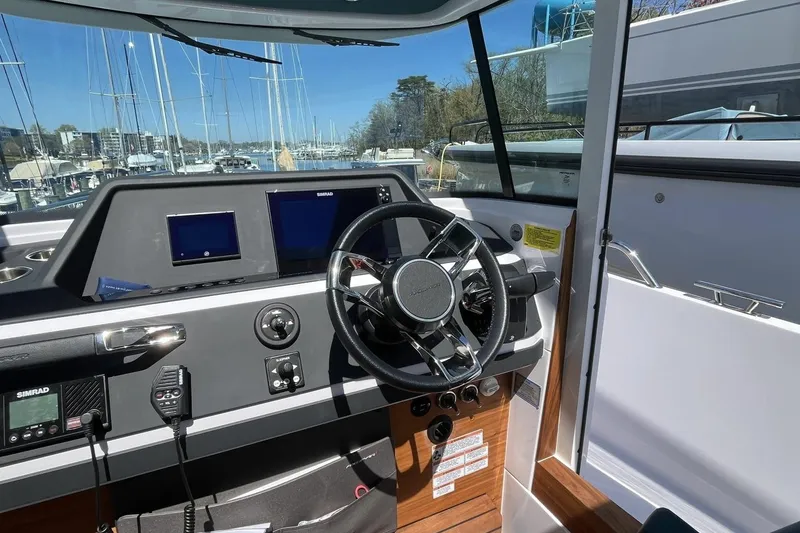 Slide: The Image of Interior view of 2023 Axopar 28 Cabin boat with modern dashboard and steering wheel. - 33