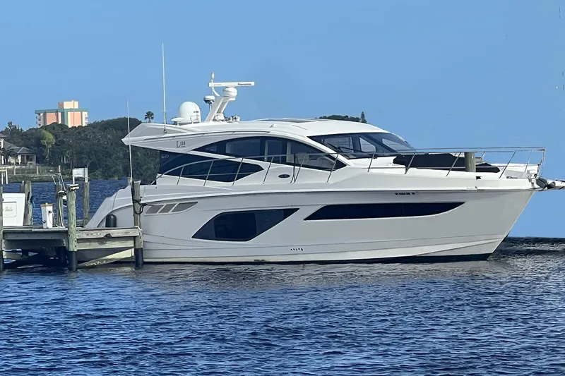 The Image of 2019 Sea Ray L550 yacht docked by waterfront buildings. - 0