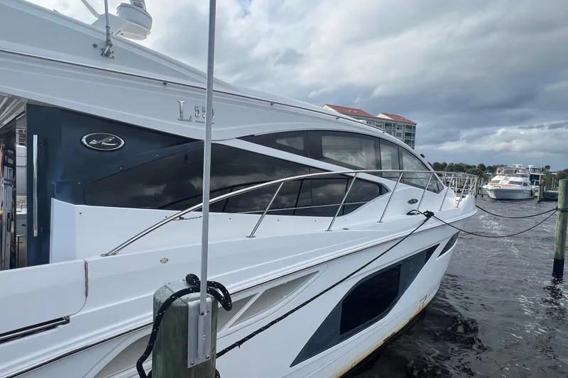 Slide: The Image of 2019 Sea Ray L550 yacht on calm blue water, side view. - 2