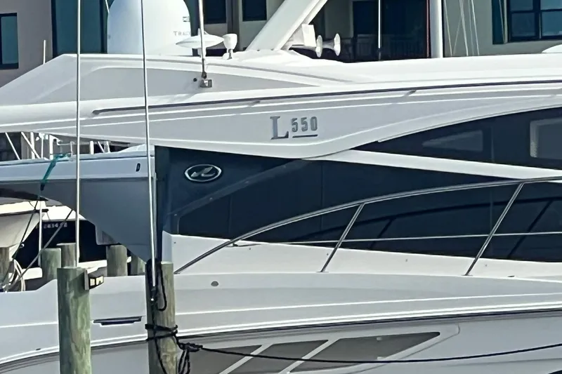 Slide: The Image of 2019 Sea Ray L550 yacht on calm water with buildings in the background. - 3