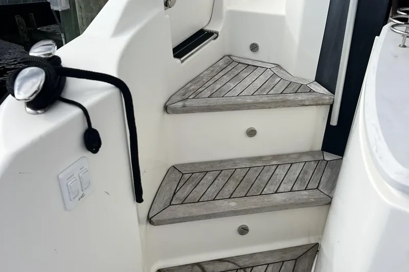 Slide: The Image of 2019 Sea Ray L550 yacht docked, showcasing sleek side deck and railing. - 9