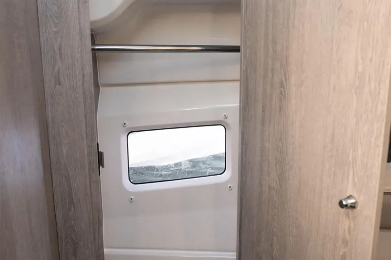 Slide: The Image of Manufacturer Provided Image: 2025 Bayliner Trophy T29 Explorer interior with window and wooden cabinetry. - 7