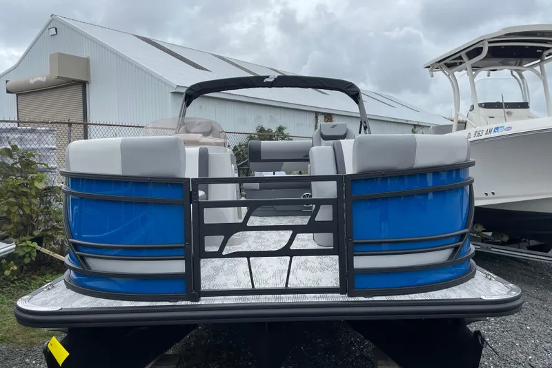 Slide: The Image of 2026 Starcraft EXS 3 DL pontoon boat with blue exterior, docked outdoors. - 2
