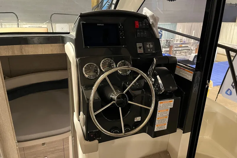 Slide: The Image of 2026 Bayliner Trophy T29 Explorer helm with steering wheel and control panel. - 10