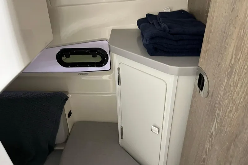 Slide: The Image of 2026 Bayliner Trophy T29 Explorer cabin interior with storage and window. - 11