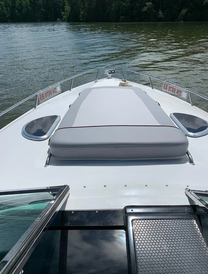 Slide: The Image of Cobalt 360 boat deck, 2005 model, on calm water with lush greenery in background. - 6