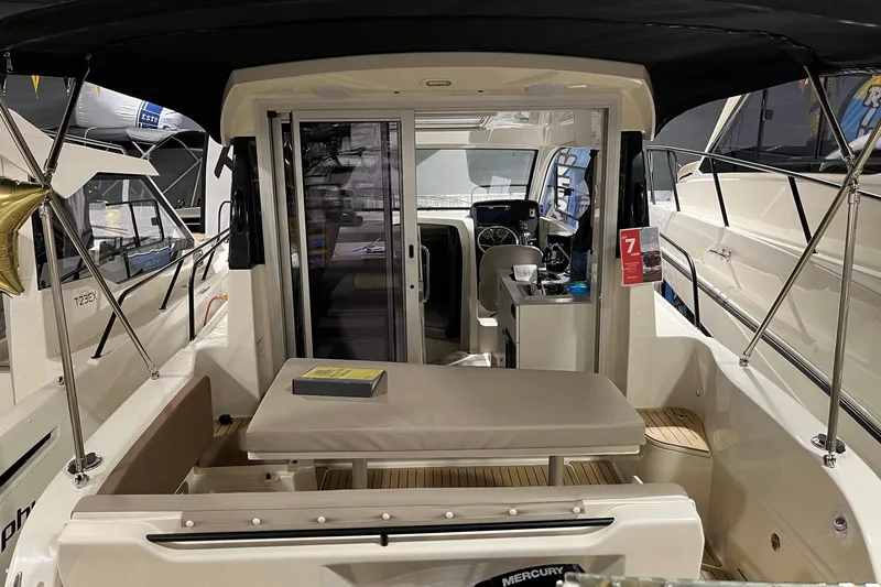 Slide: The Image of 2026 Bayliner Trophy T25 Explorer interior with seating and helm, showcased at a boat exhibition. - 13