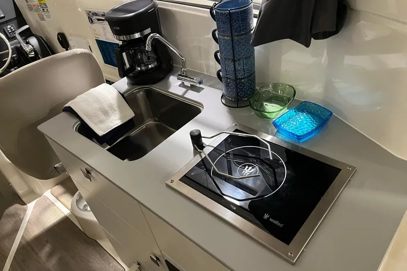 Slide: The Image of Compact kitchen area in 2026 Bayliner Trophy T25 Explorer with sink and stove. - 15