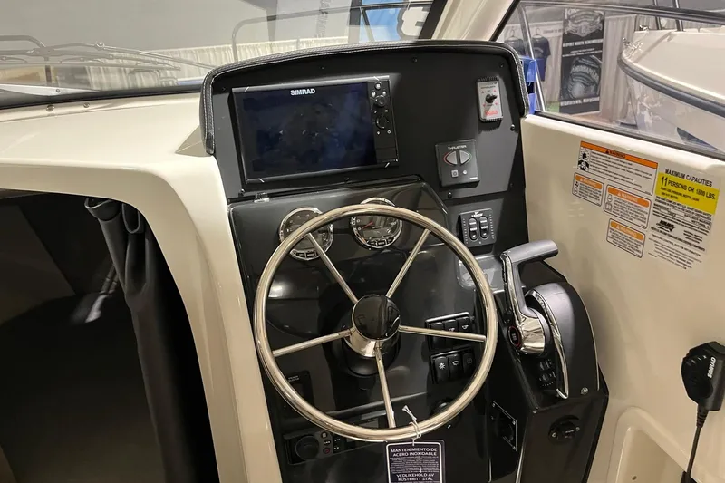 Slide: The Image of 2026 Bayliner Trophy T25 Explorer helm with steering wheel and navigation controls. - 8