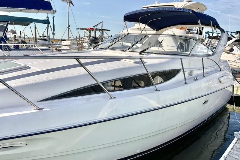 The Image of 2003 Bayliner 3055 Ciera yacht docked at marina, featuring sleek design and blue canopy. - 0