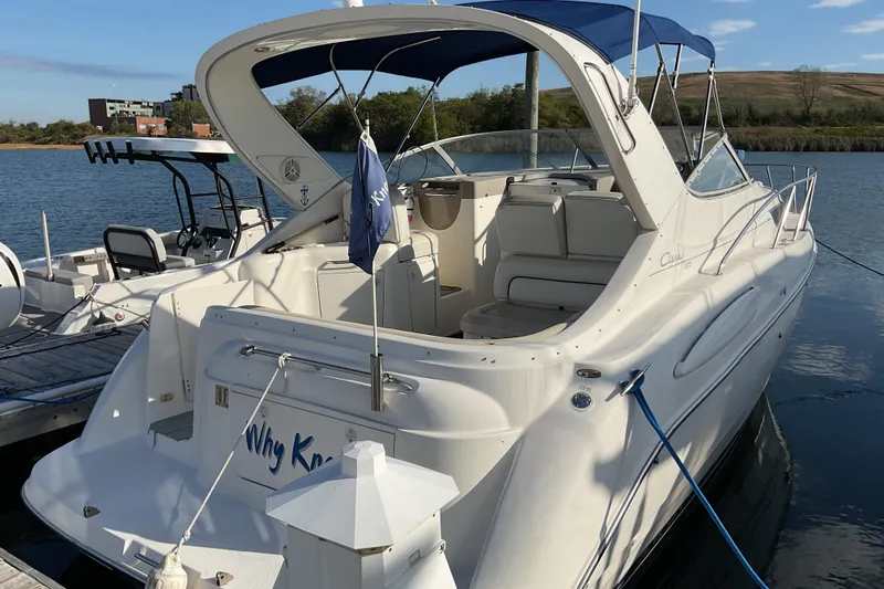 Slide: The Image of 2003 Bayliner 3055 Ciera boat docked at a marina with blue canopy. - 2