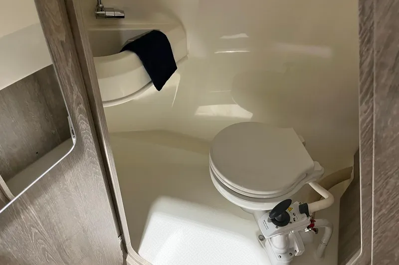 Slide: The Image of 2026 Bayliner Trophy T23 Explorer boat bathroom with compact toilet and sink. - 13