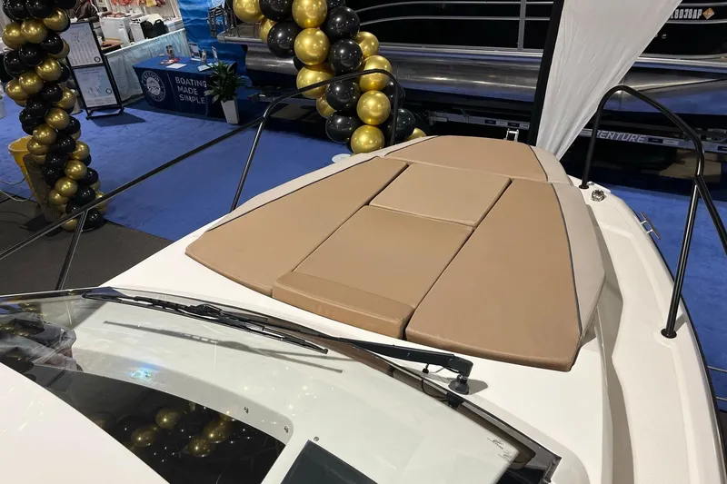 Slide: The Image of 2026 Bayliner Trophy T23 Explorer boat with tan cushions at a boat show display. - 14