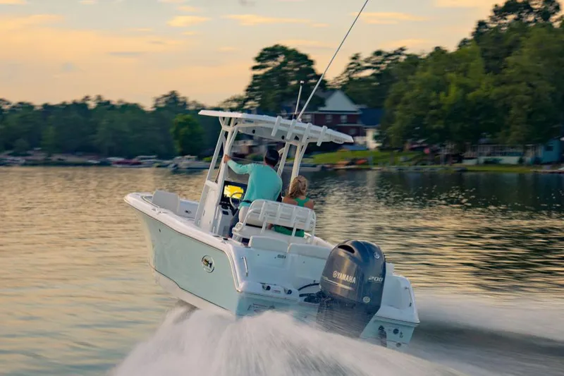 Slide: The Image of 2021 Sea Hunt Ultra 234 boat interior with console and seating under a canopy. - 2