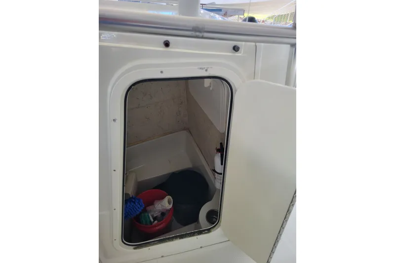 Slide: The Image of 2006 Sailfish 218 CC boat storage compartment with cleaning supplies and equipment. - 5