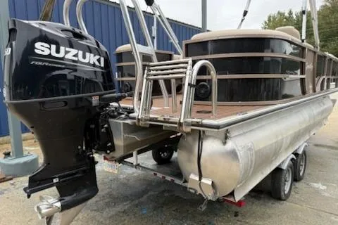 Slide: The Image of 2021 Bentley Pontoons 220 Elite Admiral with Suzuki outboard motor, docked on a trailer. - 2