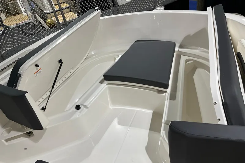 Slide: The Image of 2026 Bayliner Trophy T22CC boat interior with cushioned seating and storage compartments. - 13
