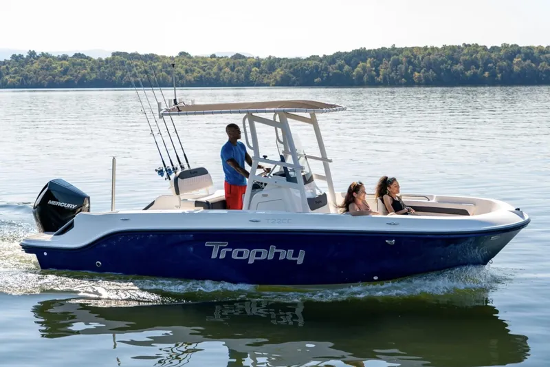 Slide: The Image of Manufacturer Provided Image: 2025 Bayliner Trophy T22CC boat cruising on a calm lake with passengers onboard. - 2
