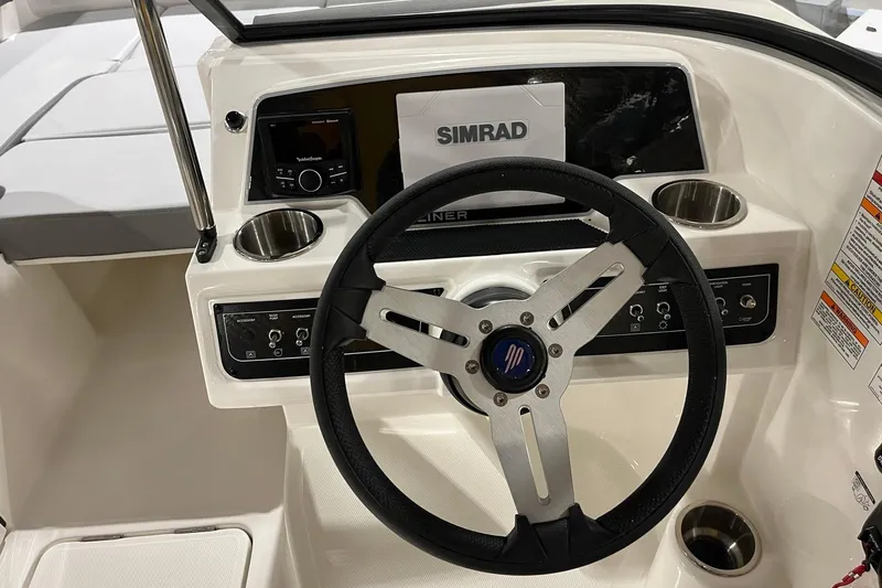 Slide: The Image of 2026 Bayliner D22 boat dashboard with steering wheel and Simrad navigation system. - 11