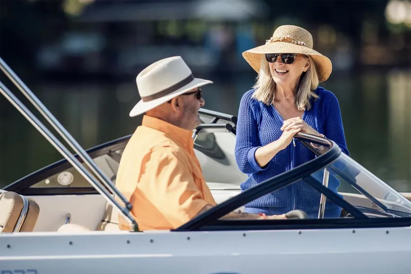 Slide: The Image of Manufacturer Provided Image: Couple enjoying a day on a 2025 Bayliner D22 boat, wearing sun hats and sunglasses. - 3