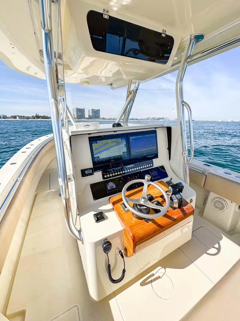 Slide: The Image of 2012 Contender 39 ST boat helm with dual screens and steering wheel on open water. - 15