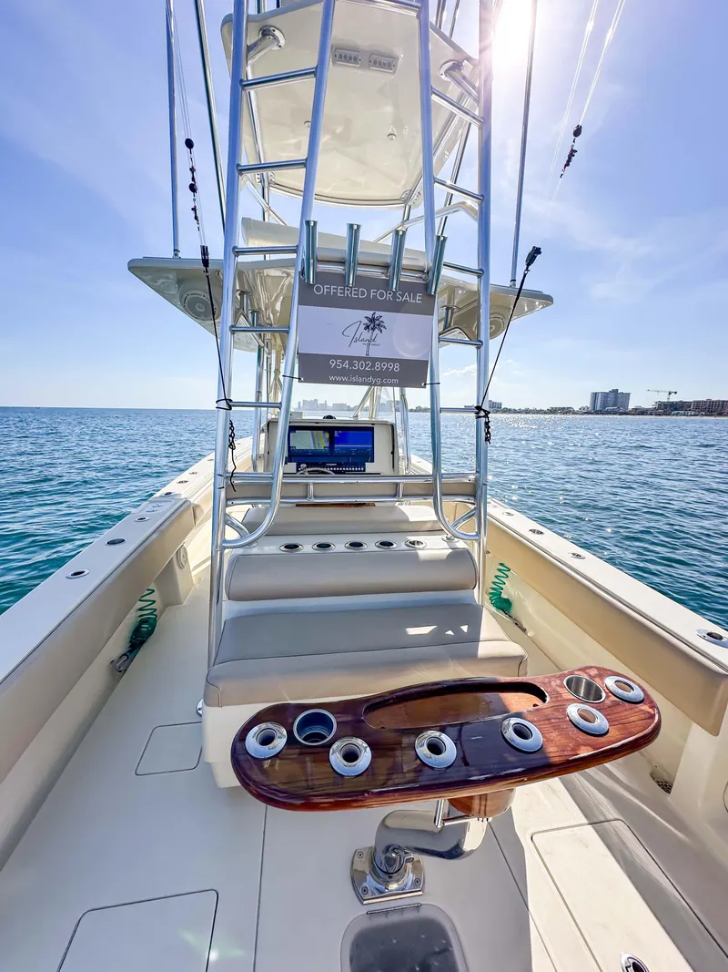 Slide: The Image of 2012 Contender 39 ST boat interior with fishing rod holders, ocean view, and sunny sky. - 17