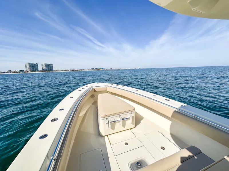 Slide: The Image of 2012 Contender 39 ST boat on open water, clear sky, distant buildings. - 23