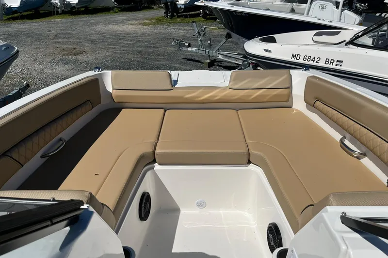 Slide: The Image of 2026 Bayliner D22 boat interior with tan cushioned seating and sleek design. - 15