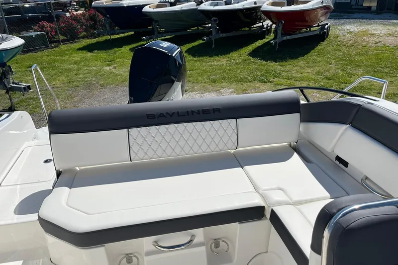 Slide: The Image of 2026 Bayliner D22 boat interior with cushioned seating and outboard motor. - 19