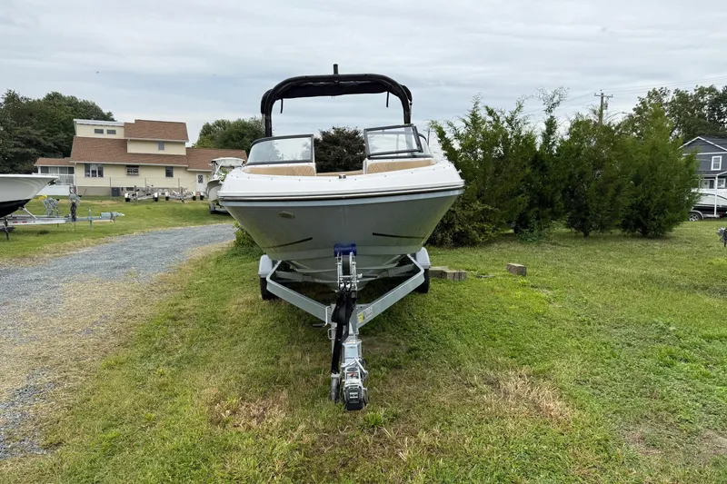 The Image of 2025 Bayliner VR6 Bowrider I/O on trailer, parked on grass, side view. - 1