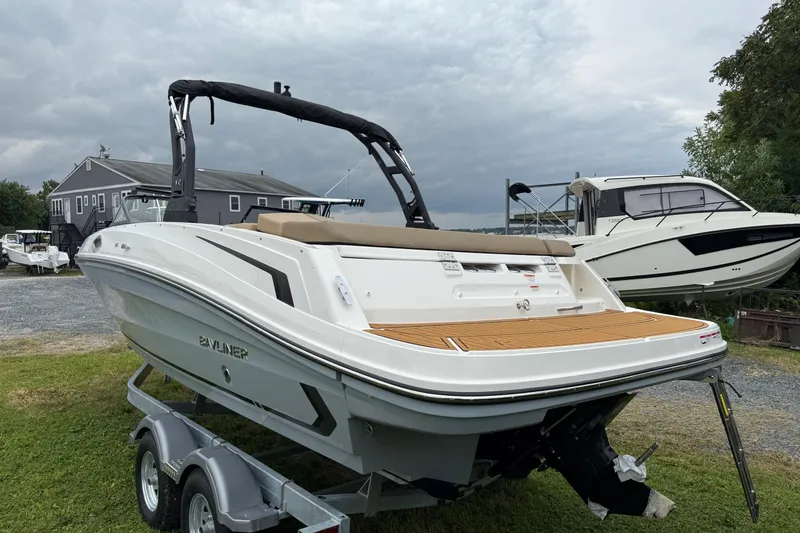 Slide: The Image of 2025 Bayliner VR6 Bowrider I/O on trailer, parked outdoors near trees and houses. - 3
