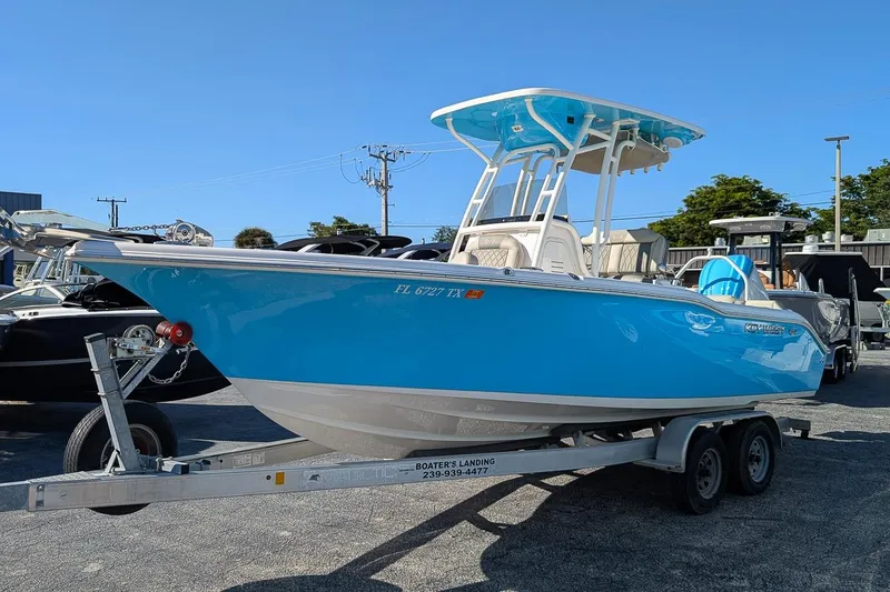 Slide: The Image of 2025 Key West 239 FS boat in vibrant blue on a trailer, parked outdoors. - 1