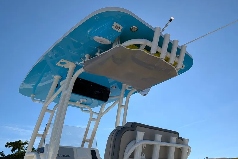 Slide: The Image of 2025 Key West 239 FS boat with blue T-top and rod holders against clear sky. - 20