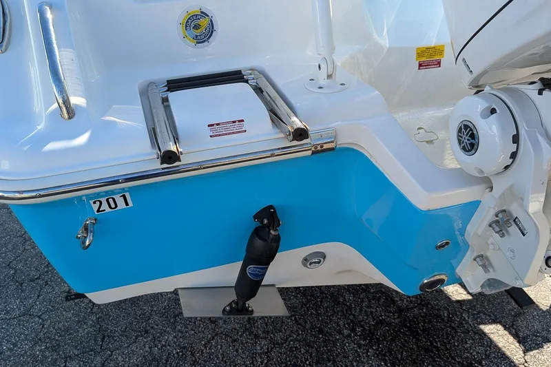 Slide: The Image of 2025 Key West 239 FS boat stern with ladder and motor, blue and white design. - 6