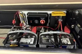 Slide: The Image of Battery compartment of 2025 Berkshire 23ULESTS3-93 with dual batteries and wiring setup. - 16