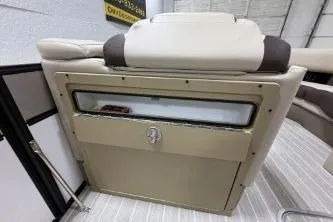 Slide: The Image of 2025 Berkshire 23ULESTS3-93 boat interior with beige seating and storage compartment. - 5