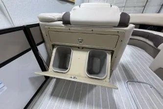 Slide: The Image of 2025 Berkshire 23ULESTS3-93 boat interior with built-in storage and cup holders. - 6