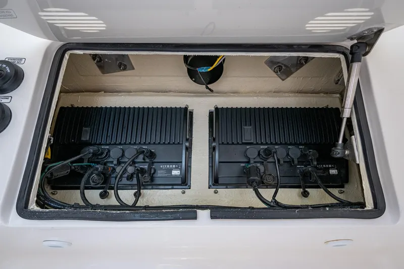 Slide: The Image of 2024 SeaVee 322z boat electronics compartment with dual black control units. - 14