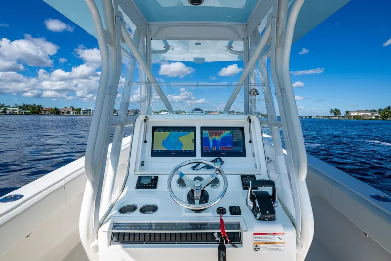 Slide: The Image of 2024 SeaVee 322z boat dashboard with navigation screens on a sunny day. - 16
