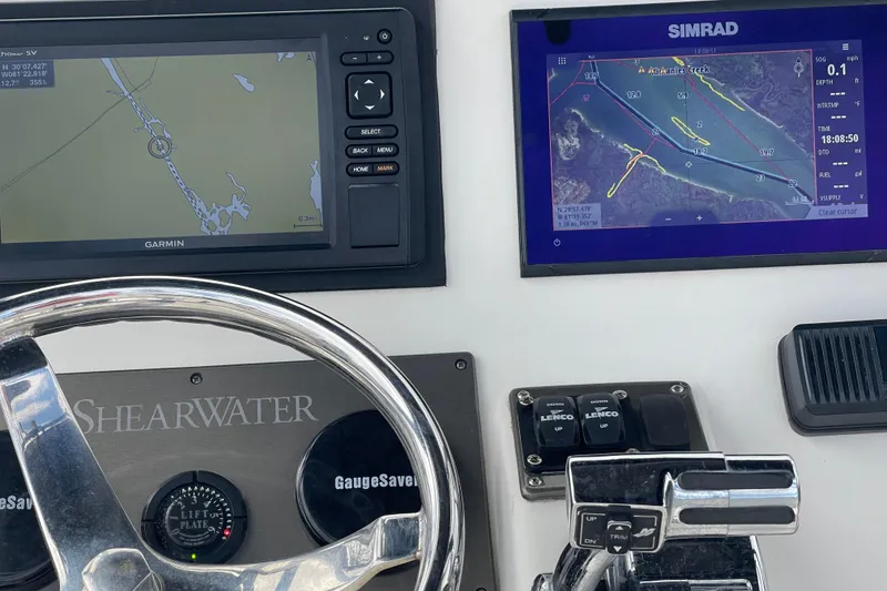 Slide: The Image of 2014 ShearWater 23TE boat console with steering wheel, navigation screens, and controls. - 11