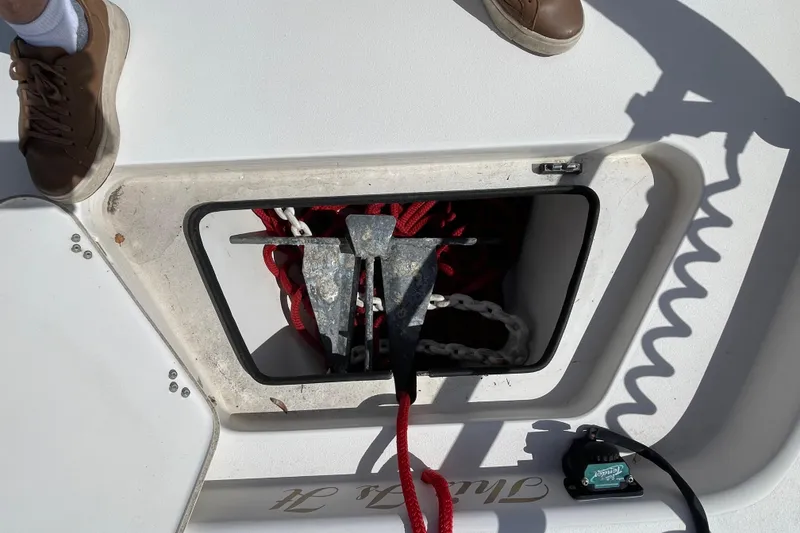 Slide: The Image of Minn Kota trolling motor on 2014 ShearWater 23TE boat, parked near a black SUV. - 23