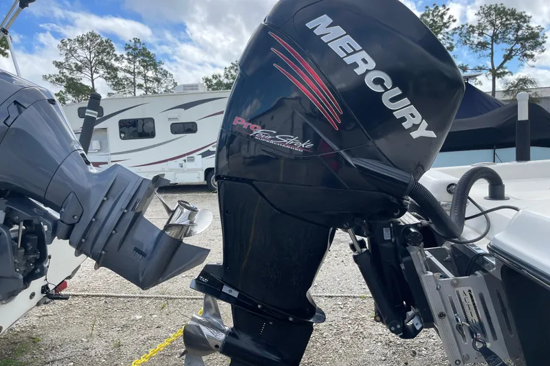 Slide: The Image of 2014 ShearWater 23TE boat with console and seating, parked outdoors under cloudy sky. - 8