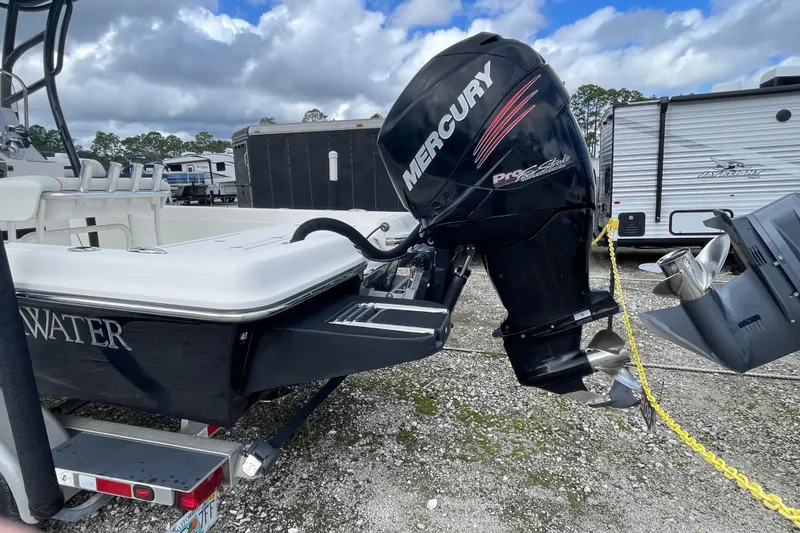 Slide: The Image of 2014 ShearWater 23TE boat with Mercury Pro XS outboard motor, parked near RV. - 9