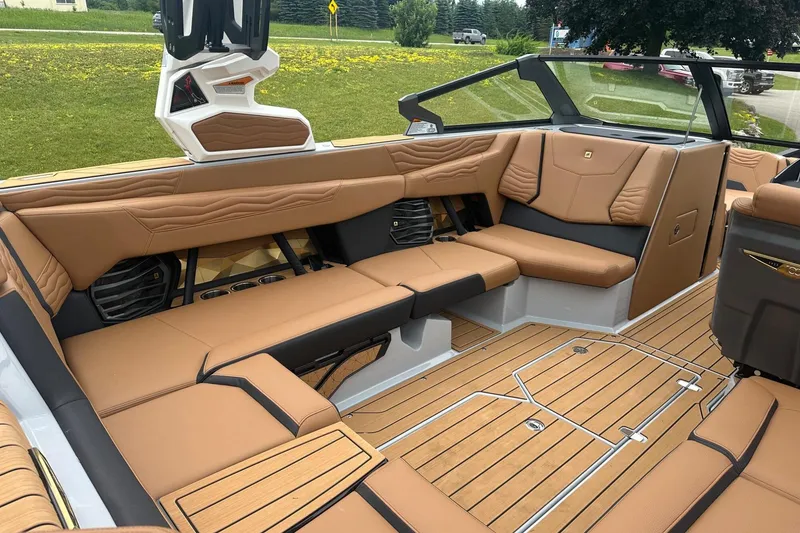 Slide: The Image of 2025 Nautique Super Air Nautique G23 interior with tan leather seating and teak flooring. - 10