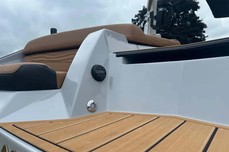 Slide: The Image of 2025 Nautique Super Air Nautique G23 boat interior with tan seating and teak flooring. - 14